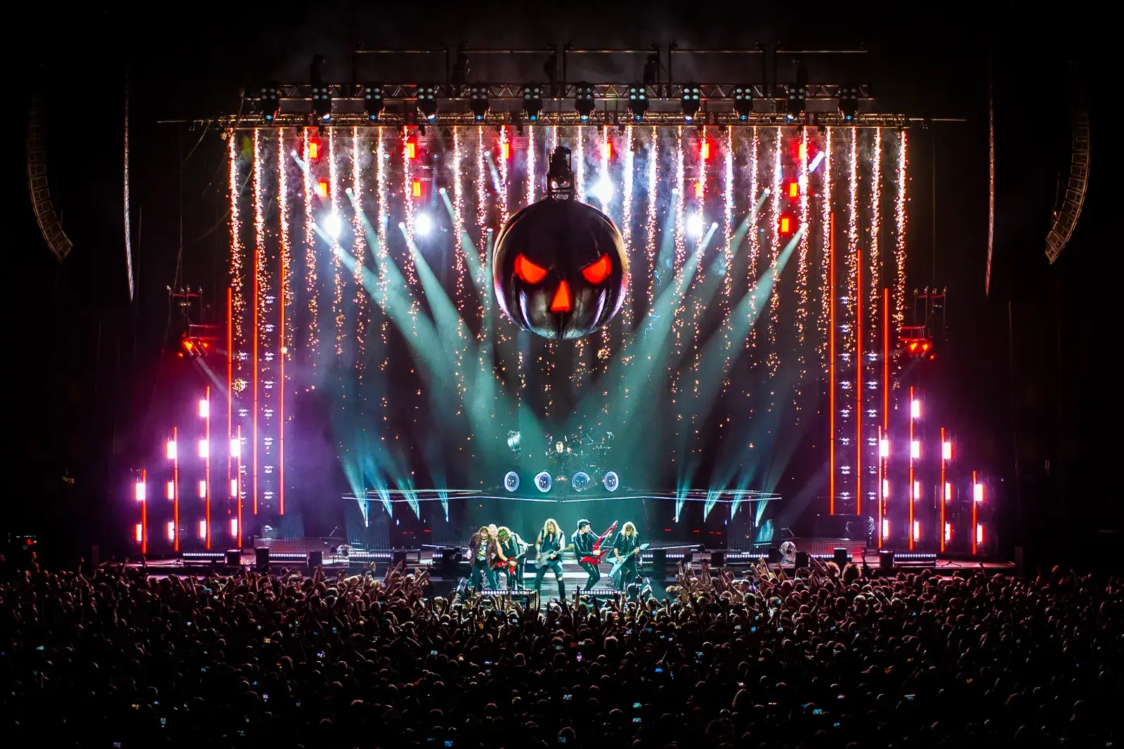 Arena stage with a large light show in front of a full crowd