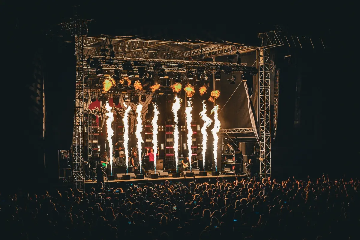 Pyrotechnic flames above a festival stage at night