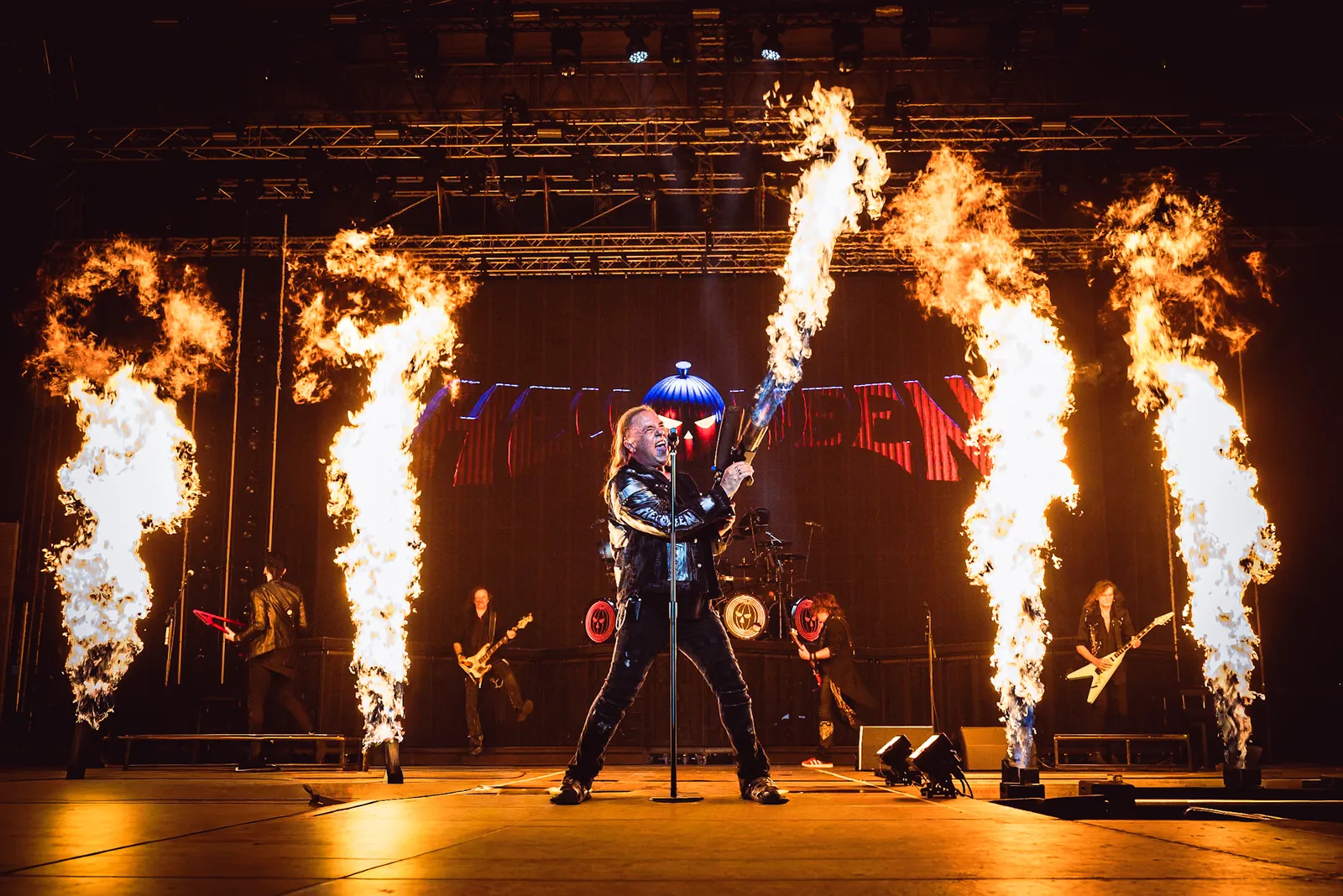 Singer with a flamethrower between pyro columns on stage
